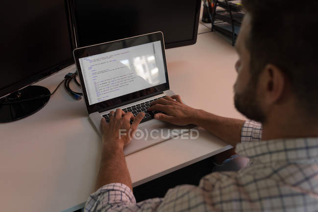 Homme d'affaires en utilisant un ordinateur portable au bureau — Photo de stock