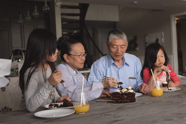Nonni e nipoti che hanno torta di compleanno a casa — Foto stock