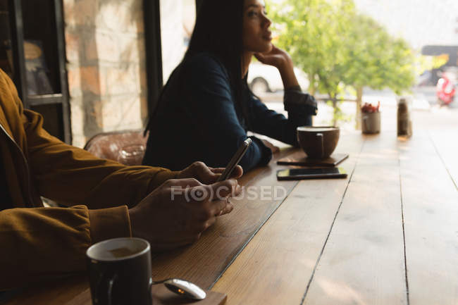 Крупный план человека с помощью мобильного телефона в кафе — стоковое фото