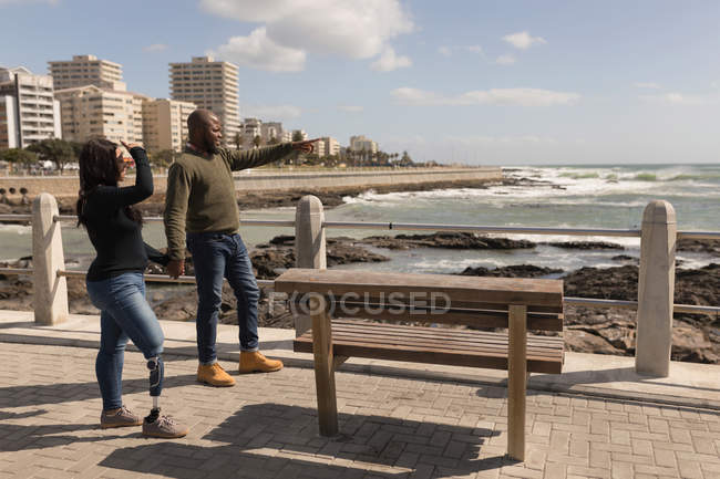 Paar hält Händchen auf Promenade am Meer — Stockfoto