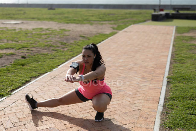 Corredor feminino se exercitando no parque em um dia ensolarado — Fotografia de Stock