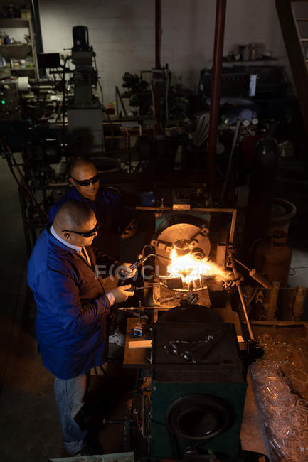 Zwei männliche Arbeiter, die in der Glasfabrik arbeiten — Stockfoto