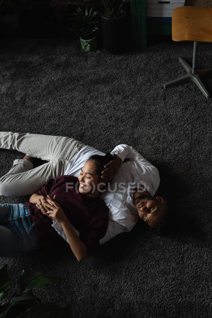 Couple relaxant sur le sol dans le salon à la maison — Photo de stock