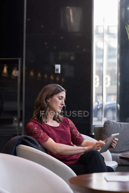 Geschäftsfrau nutzt digitales Tablet auf Sofa im Hotel — Stockfoto