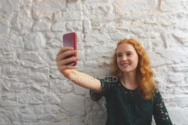 Redhead woman taking selfie in cafe — Stock Photo