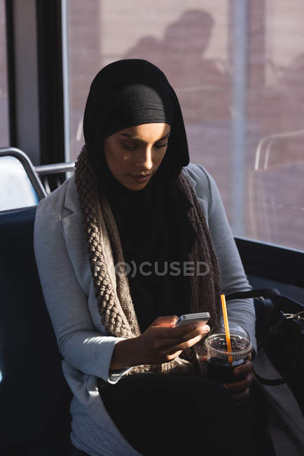 Hijab woman using mobile phone while travelling in train — Stock Photo