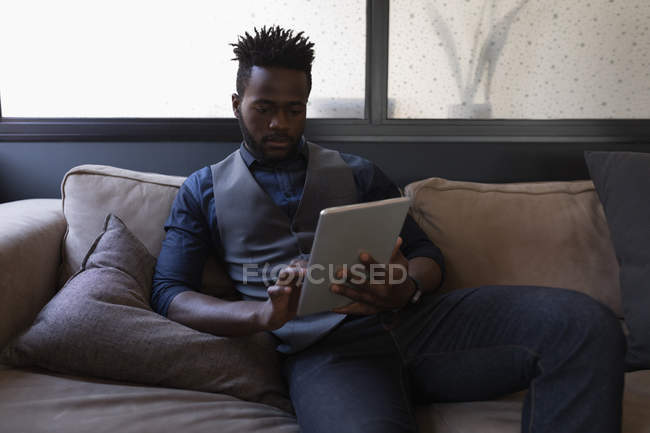 Hombre de negocios inteligente usando tableta digital en la oficina - foto de stock