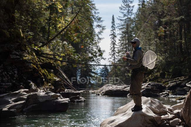 Pesca con mosca en el río en un día soleado - foto de stock