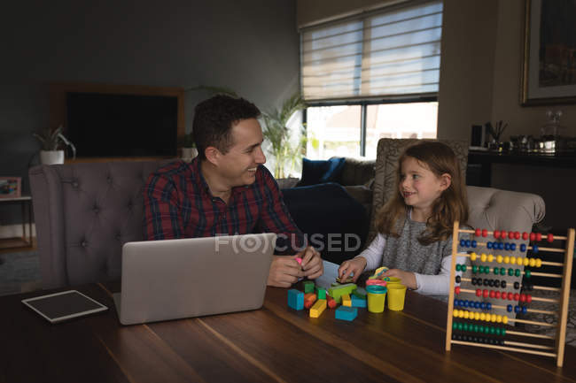 Padre che gioca con sua figlia in salotto a casa — Foto stock