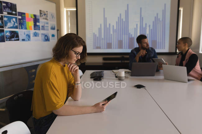 Ejecutiva femenina usando tableta digital en sala de conferencias en la oficina - foto de stock