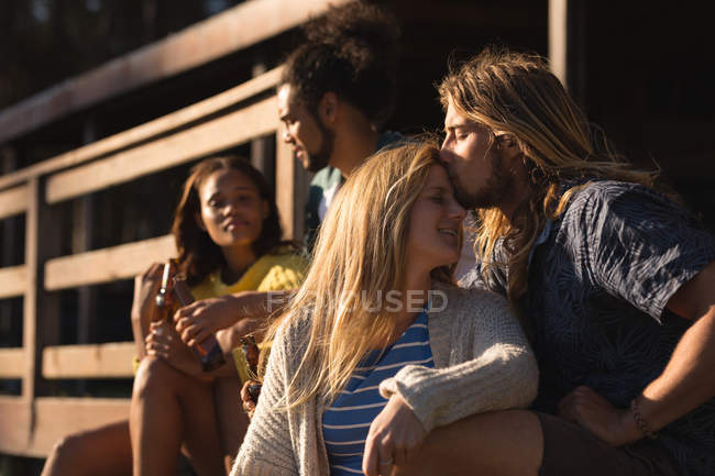 Joven hombre besar mujer cabeza en cabina - foto de stock