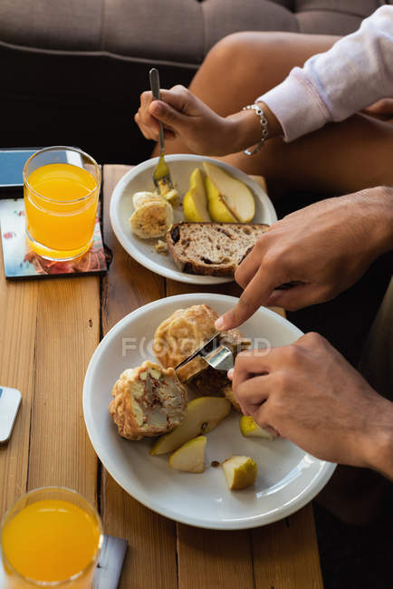 Close-up of couple having food in living room at home — Stock Photo