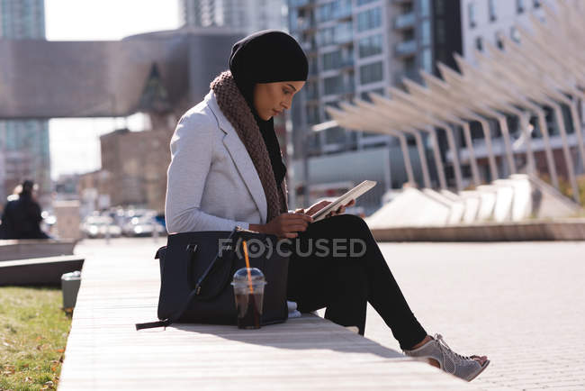 Хиджаб женщина с помощью цифрового планшета в городе — стоковое фото