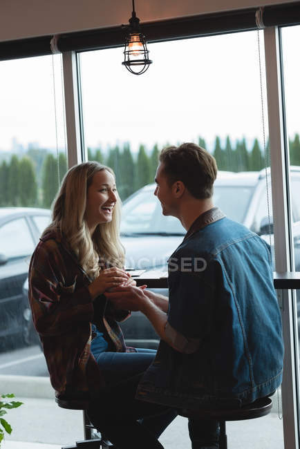 Casal feliz interagindo uns com os outros no café — Fotografia de Stock
