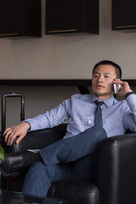 Empresário falando no celular no lobby do hotel — Fotografia de Stock
