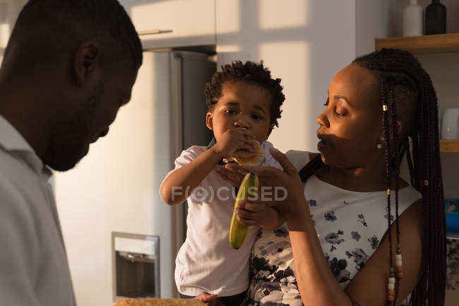 Madre che alimenta il figlio in cucina a casa — Foto stock