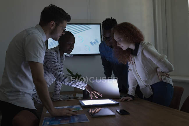 Руководители обсуждают за цифровым планшетом в конференц-зале в офисе — стоковое фото