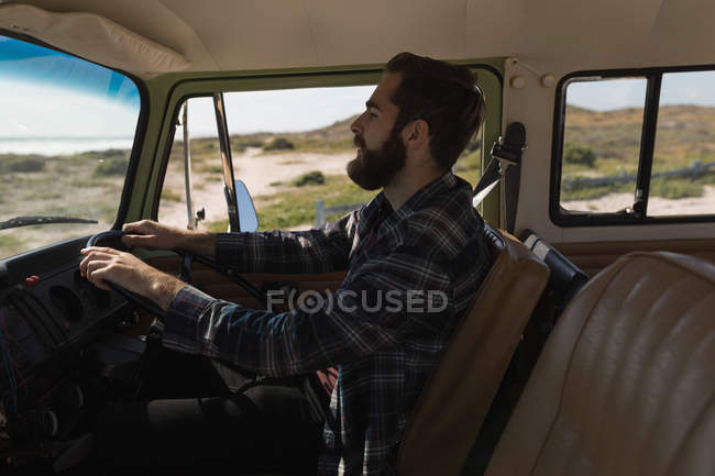 Side view of man driving car during roadtrip — Stock Photo