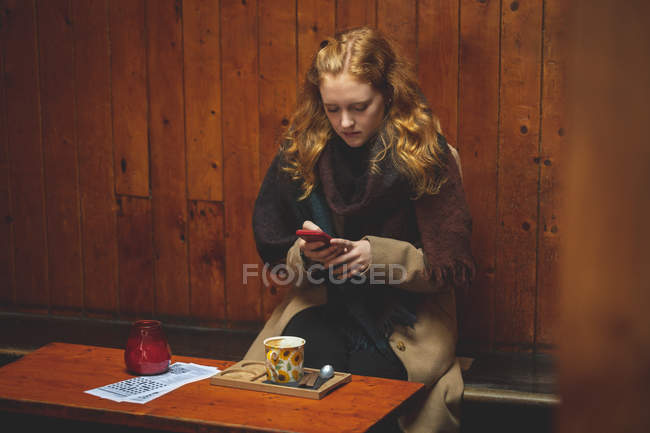 Mulher ruiva usando telefone celular no café — Fotografia de Stock