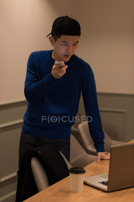 Male executive talking on mobile phone in conference room at office — Stock Photo