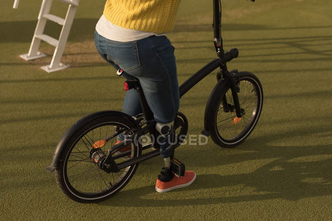 Section basse de la femme handicapée assise sur le vélo — Photo de stock