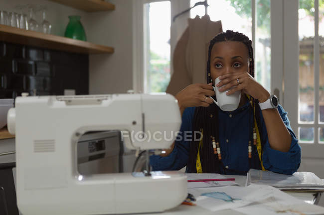 Fashion designer having cup of coffee at home — Stock Photo