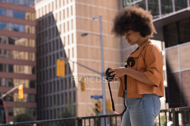 Frau überprüft Fotos vor der Kamera in der Stadt — Stockfoto