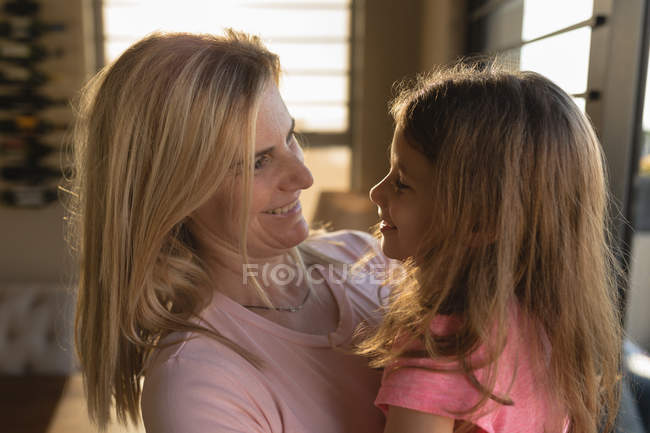 Felice madre che tiene sua figlia a casa — Foto stock