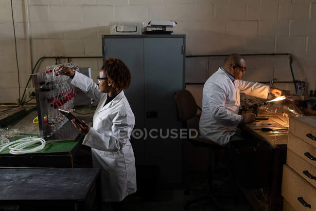 Vista laterale dei lavoratori che lavorano in fabbrica di vetro — Foto stock