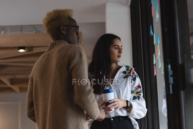 Business executives discussing over a sticky notes in office — Stock Photo