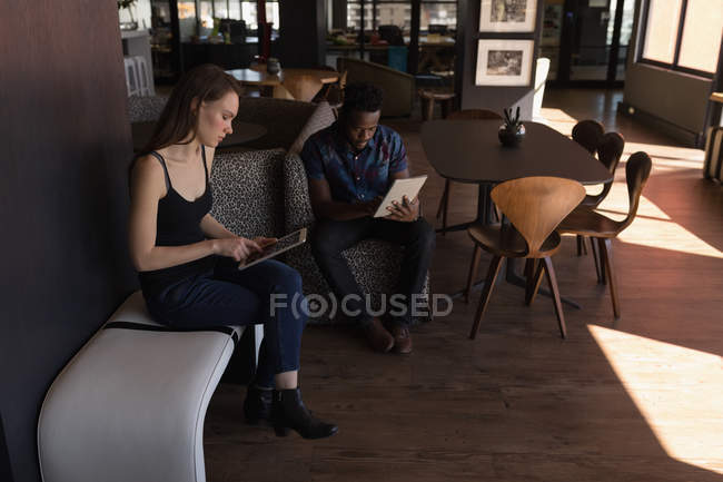 Бізнес-колеги використовують цифровий планшет в кафетерії в офісі — стокове фото