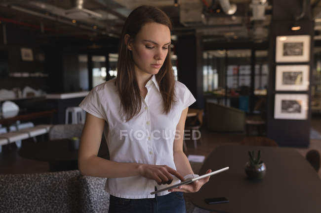 Beautiful female executive using digital tablet in office — Stock Photo