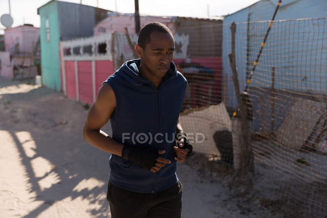 Homme athlète jogging près du village par une journée ensoleillée — Photo de stock