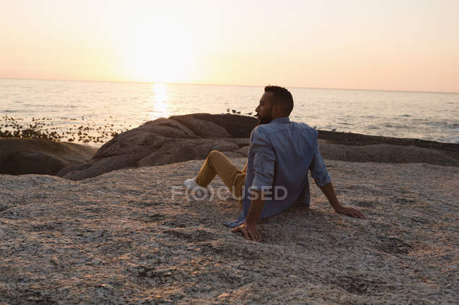 Розумний чоловік сидить на пляжі — стокове фото