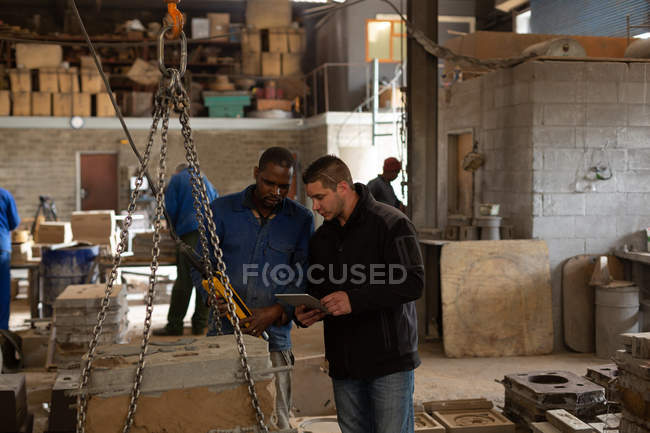 Travailleurs masculins discutant en atelier de fonderie — Photo de stock