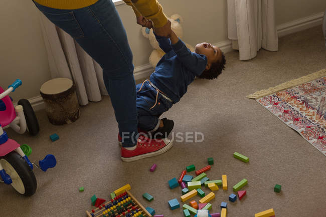 Mother and son playing in a living room at home — Stock Photo