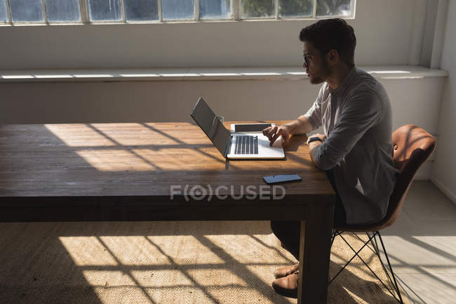 Executivo masculino usando laptop na sala de conferências no escritório — Fotografia de Stock