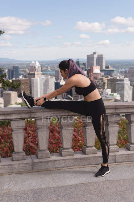 Young female jogger stretching on a sunny day — Stock Photo