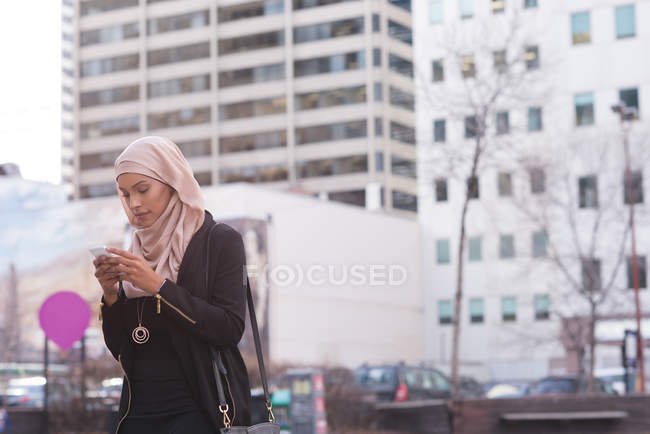 Hijab mujer usando el teléfono móvil en la ciudad - foto de stock