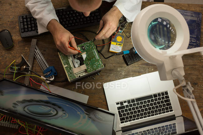 Hoch-Winkel-Ansicht des Robotik-Ingenieurs beim Bestücken der Leiterplatte am Schreibtisch — Stockfoto