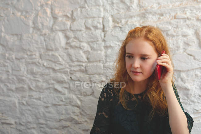 Redhead woman talking on mobile phone in cafe — Stock Photo