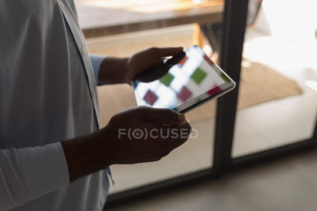 Мидсекция мужчины-руководителя с использованием цифрового планшета в конференц-зале — стоковое фото