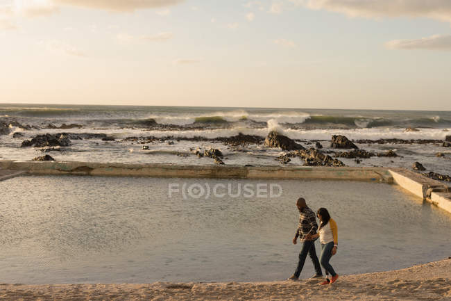Vista de alto ângulo de casal de mãos dadas e andando no passeio marítimo — Fotografia de Stock