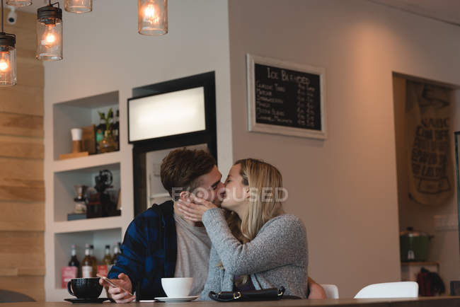 Pareja romántica besándose en la cafetería - foto de stock