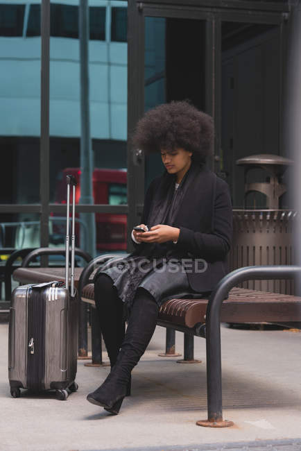 Giovane donna che utilizza il telefono cellulare in città — Foto stock