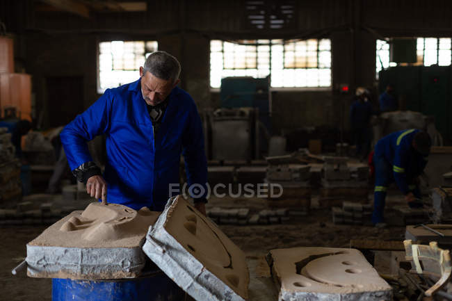 Lavoratore maschio che fa fonderia stampaggio in officina — Foto stock