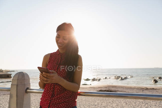 Красива жінка використовує мобільний телефон на набережній — стокове фото