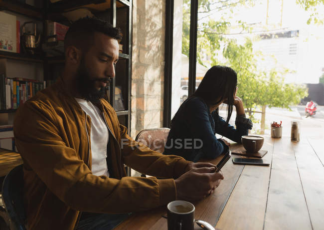 Вид збоку людини, що використовує мобільний телефон у кафе — стокове фото