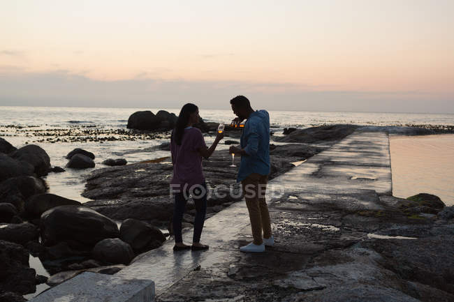 Romantisches Paar mit Champagner in der Nähe des Meeres — Stockfoto