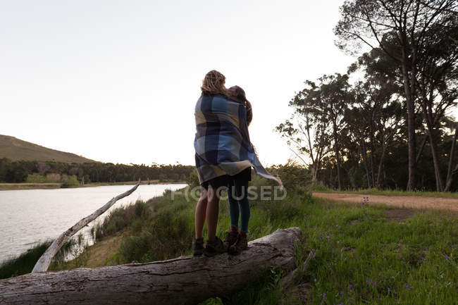 Romantic couple wrapped in blanket at campsite — Stock Photo